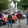 A FULL CAR PARK WITH CLUB MEMBERS VIEWING THE LINED UP CARS.